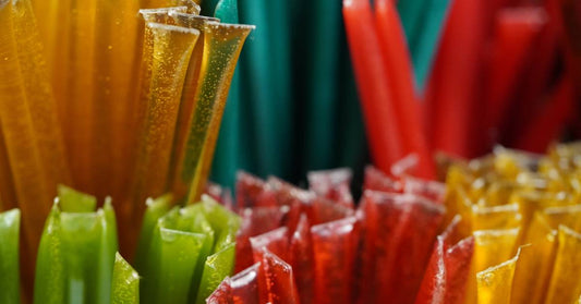Extreme close up of the ends of several different colors and flavors of honey sticks showing their variety.